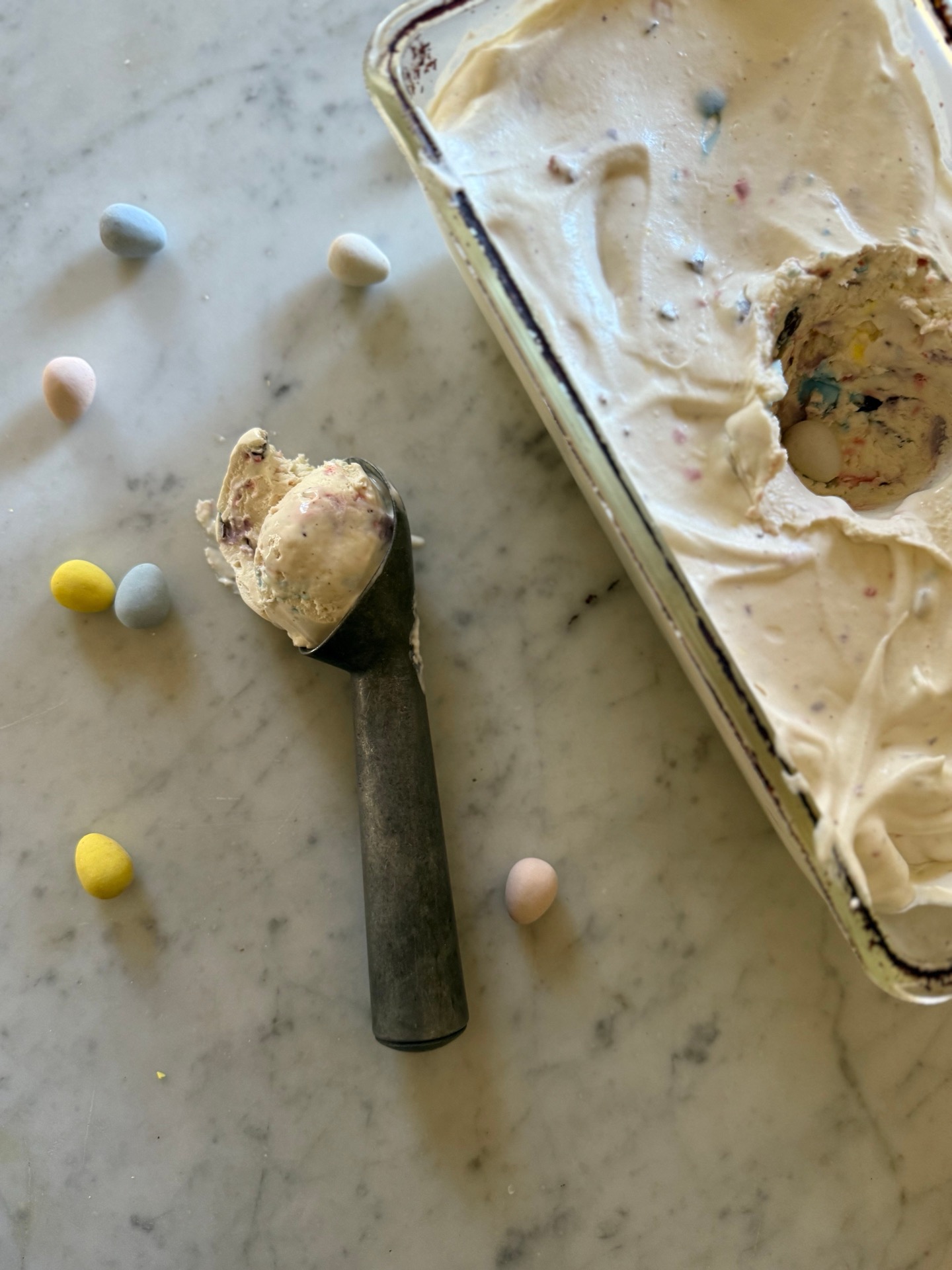 Scoop of Cadbury Mini Egg ice cream on a marble surface